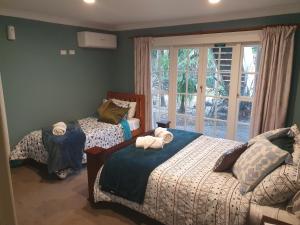 WhatawhataにあるKoromatua Homesteadのベッドルーム1室(ベッド2台、窓付)