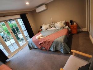 a bedroom with a bed and a large window at Koromatua Homestead in Whatawhata