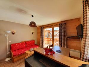 a living room with a red couch and a table at Les Chalets Des Rennes - VARS - T2 4 personnes - CDRA53 in Vars