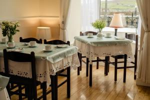 丁格爾的住宿－The Waterfront，一间带2张桌子和椅子的用餐室以及窗户。