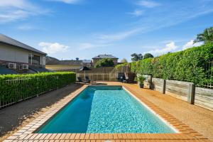 a swimming pool in the backyard of a house at Ambassador On Ruthven in Toowoomba
