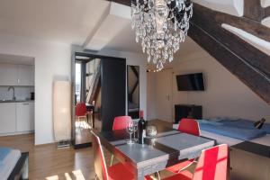 a dining room with a table and red chairs at HITrental Chapel Bridge Apartments in Lucerne