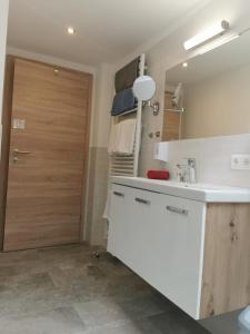 ザンクト・ヴォルフガングにあるApartmenthaus WALDHORNのキッチン(白いカウンター、木製のドア付)