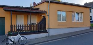 Una bicicleta blanca estacionada frente a una casa en Ferienwohnung Kell am See en Kell