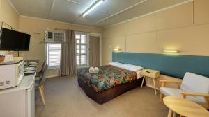 sypialnia z łóżkiem, biurkiem i telewizorem w obiekcie Matilda Motel w mieście Winton