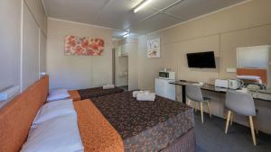 a hotel room with a bed and a television at Matilda Motel in Winton