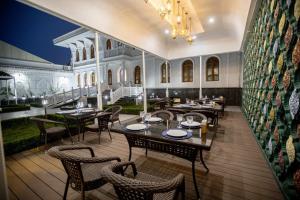 a restaurant with tables and chairs and a wall at The Shahar in Tashkent