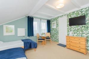 a bedroom with a bed and a tv and a table at Willa Aquarius in Karwia
