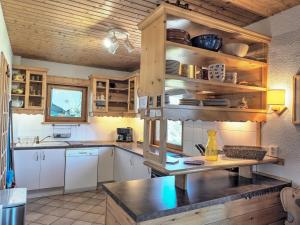 a kitchen with white cabinets and a wooden ceiling at Chardon Bleu in Peisey-Nancroix