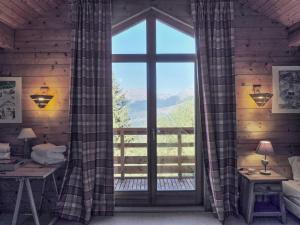 a room with a large window with a view of the mountains at Chardon Bleu in Peisey-Nancroix
