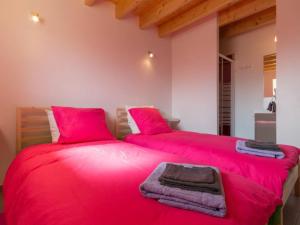 two beds in a room with red pillows and blankets at Gîte Saint-Viaud, 4 pièces, 6 personnes - FR-1-306-1047 in Saint-Viaud