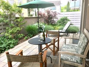 une terrasse avec une table, des chaises et un parasol dans l'établissement Weinreisedomizil mit eigenem Garten und Parkplatz, à Deidesheim