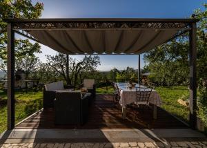 un pergolato con tavolo e sedie su un patio di Casa Clara a Montecchio