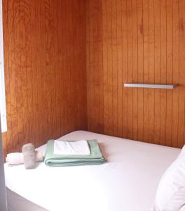 a bed with a towel and a wooden door at Résidence L'araguina in Bonifacio