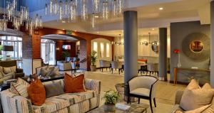 a living room with couches and a dining room at ANEW Hotel Centurion Pretoria in Centurion