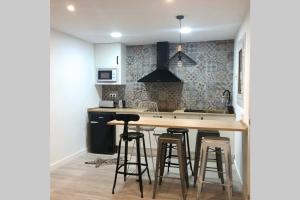 a kitchen with a wooden counter and bar stools at M5 Cool Terrace. Metro 1 min. Center 15' by metro in Esplugues de Llobregat