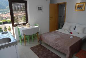 Apatmani Darija في كوميجا: غرفة نوم بسرير وطاولة ومغسلة