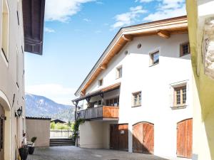 un edificio bianco con balcone e montagne sullo sfondo di Apartment in Brixlegg near Ski Juwel Slopes a Rattenberg