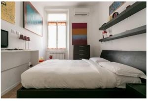 a bedroom with a large bed with white sheets at Splendido Bilocale in Via Orti - A pochi metri dal Policlinico in Milan