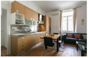 a kitchen and living room with a table and a couch at Splendido Bilocale in Via Orti - A pochi metri dal Policlinico in Milan