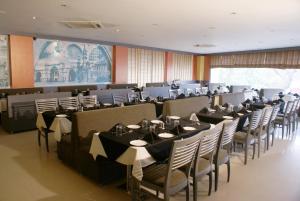 einen großen Bankettsaal mit Tischen und Stühlen darin in der Unterkunft Hotel Ashray Inn in Ahmedabad