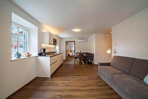 a living room with a couch and a kitchen at Engel Appartements Erker in Parcines