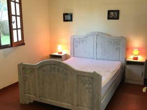 um quarto com uma cama branca e 2 candeeiros nas mesas em Gîte Saint-Hilaire-de-Riez, 4 pièces, 6 personnes - FR-1-426-279 em Saint-Hilaire-de-Riez