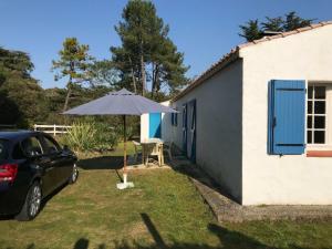 um carro estacionado ao lado de uma casa com um guarda-chuva em Gîte Saint-Hilaire-de-Riez, 4 pièces, 6 personnes - FR-1-426-279 em Saint-Hilaire-de-Riez