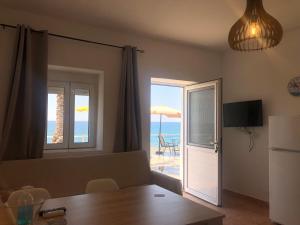 Sala de estar con mesa y vistas al océano en Myrtos Harmony Apartments, en Myrtos