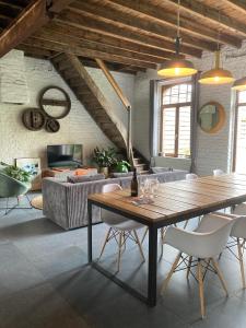 a living room with a wooden table and chairs at Kunstmin in Zandvoorde