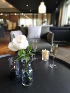 a table with a vase of flowers and glasses on it at Hotell Kristina in Sigtuna