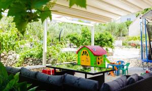 un patio con una mesa y una casa de juguetes en Apartment Gazo, en Trogir