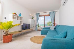 a living room with a blue couch and a tv at Surfescape Zanzibar in Kiwengwa