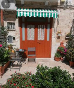 a red door with a table and chairs in front of a building at Home Sweet Home rooms in Bari