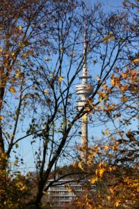 einen Blick auf den Eiffelturm durch die Bäume in der Unterkunft Business Suiten in München