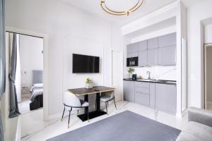 Roma Deluxe Apartments في روما: مطبخ مع طاولة وكراسي في غرفة