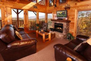a living room with leather furniture and a fireplace at His Amazing Grace in Sevierville