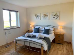 a bedroom with a large bed with blue pillows at Eastbrae Cottages & Lodges in Stromness