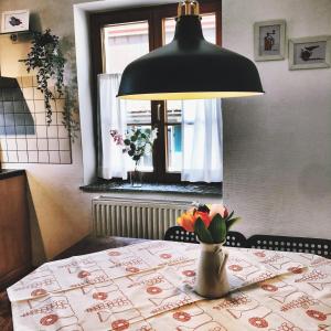 uma mesa com um candeeiro e um vaso de flores sobre ele em Apartment DOMO Kirchzarten em Kirchzarten