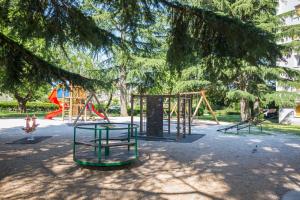 un parc avec plusieurs balançoires et une aire de jeux dans l'établissement Apartment Stella, à Labin