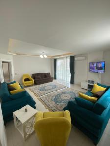 a living room with two blue couches and a rug at Moda Marine Residence in Alanya
