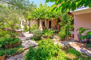 un jardin en face d'une maison ornée de plantes dans l'établissement Apartments Lavanda, à Rovinj