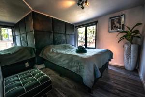 a bedroom with a bed and a chair and a plant at Amsterdam-Houseboat-Amstel in Amsterdam