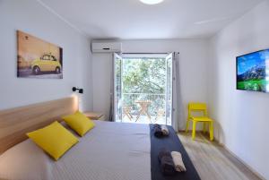 1 dormitorio con 1 cama y 1 silla amarilla en Olive Tree en Stari Grad