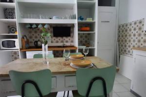 une cuisine avec une table et des chaises vertes dans l'établissement Charming Sunny Terrace / One bedroom Apartment, à Lisbonne