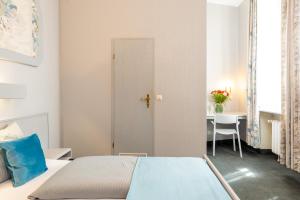 a bedroom with a bed and a desk and a table at W22 Hotel am Kurfürstendamm in Berlin