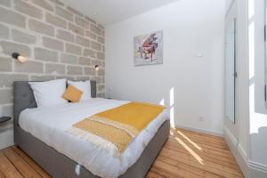 Ce lit se trouve dans une chambre dotée d'un mur en briques. dans l'établissement Hyper Centre 14 rue Valdemaine, à Angers