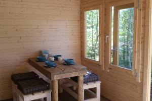 un tavolo in una baita di tronchi con ciotole blu sopra di Cozy Lodge in Värmland Sweden a Filipstad