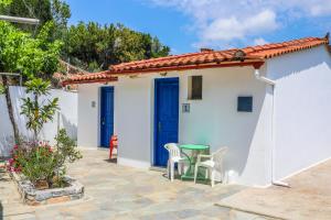 Casa blanca pequeña con mesa verde y sillas en Villa Maria Koukounaries, en Koukounaries