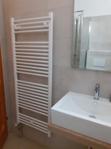 a white bathroom with a sink and a mirror at Pension Horvath jun. in Guntramsdorf +7 photos